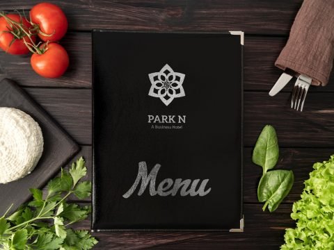 Park N hotel restaurant menu cover on a wooden table with vegetables